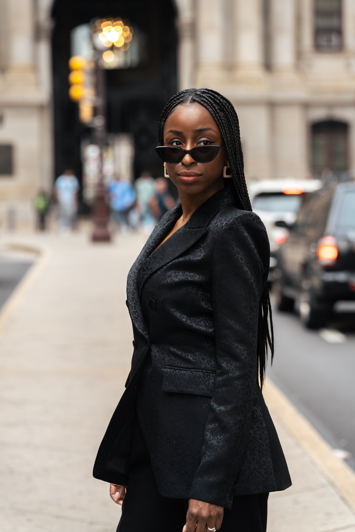 Woman in a black suit standing on a city street