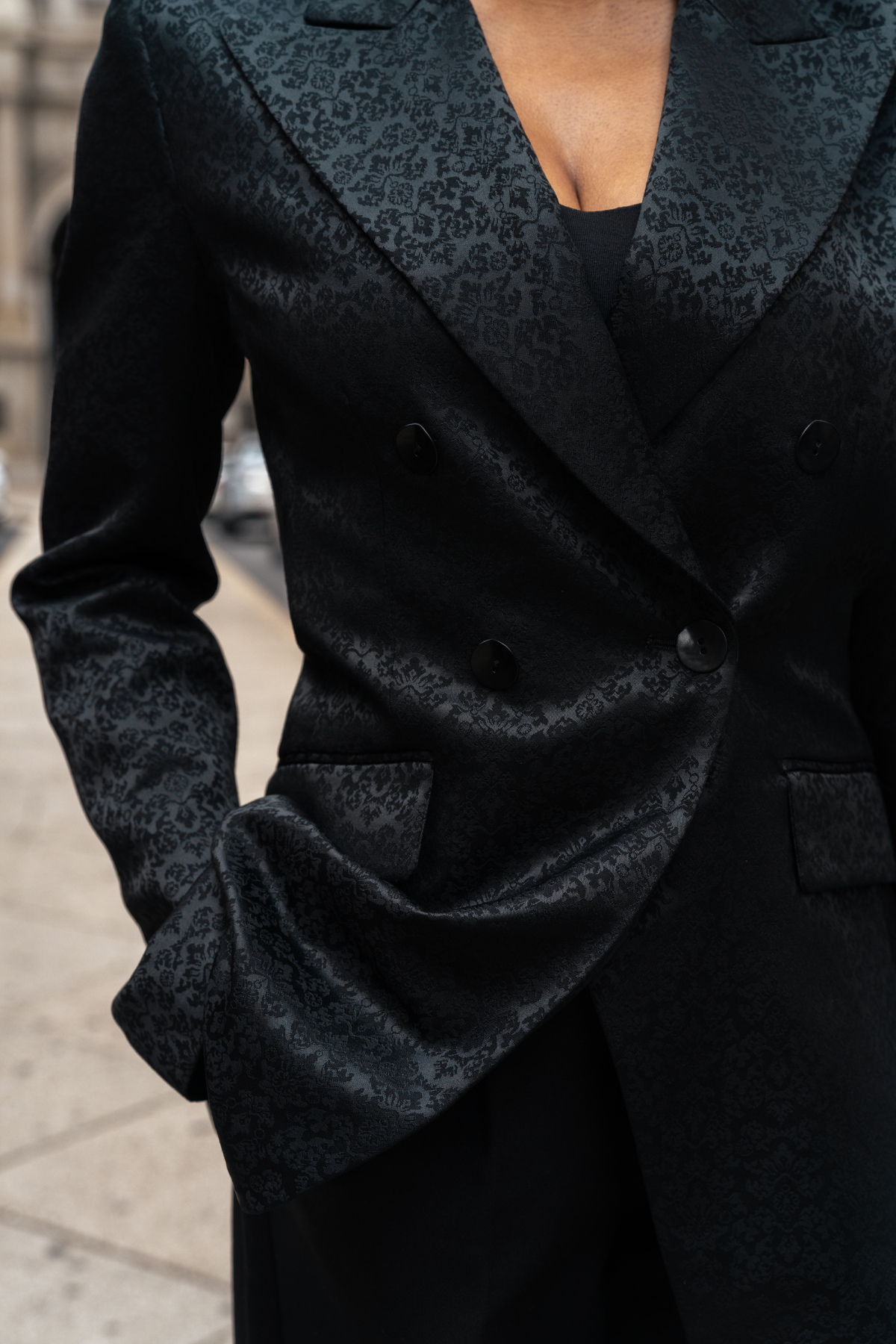 Close-up of a black textured coat with a blurred background