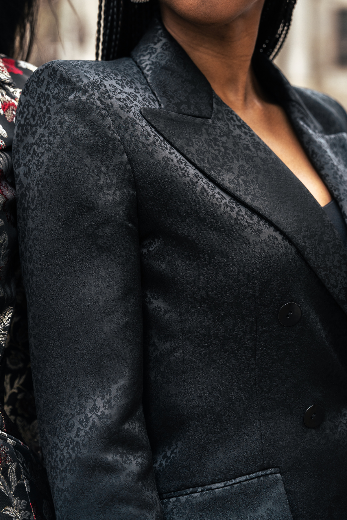 Close-up of a textured black blazer worn by a person