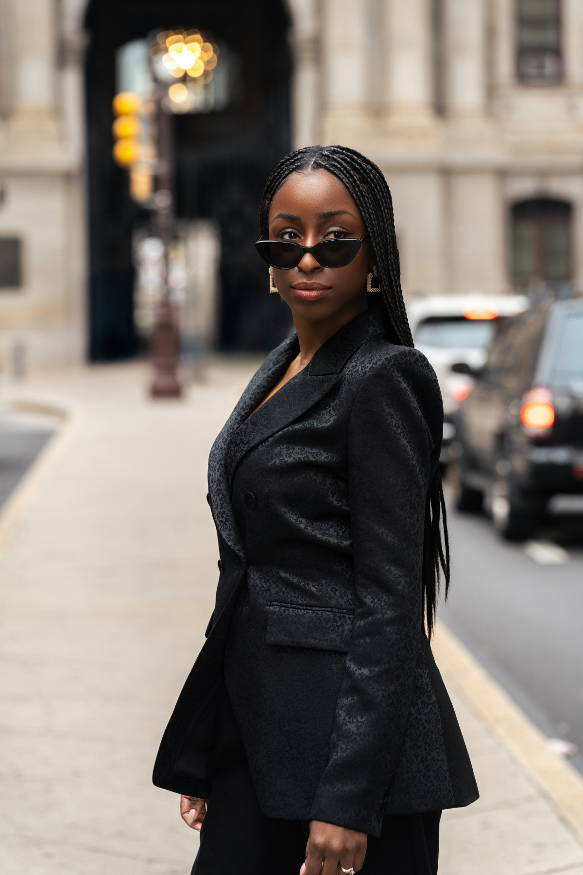 Woman in a black suit standing on a city street