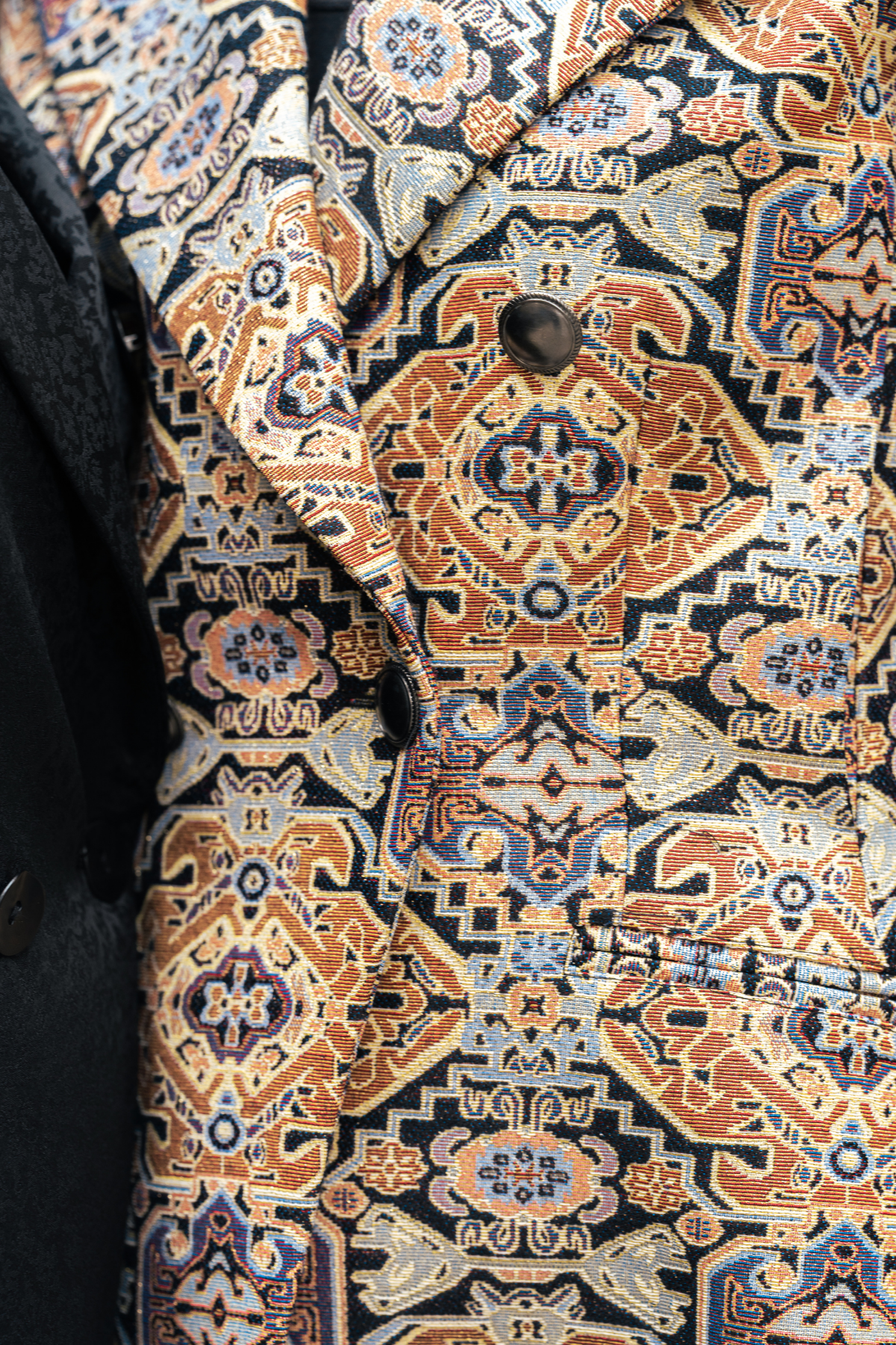 Close-up of a patterned fabric with intricate designs on a dark background