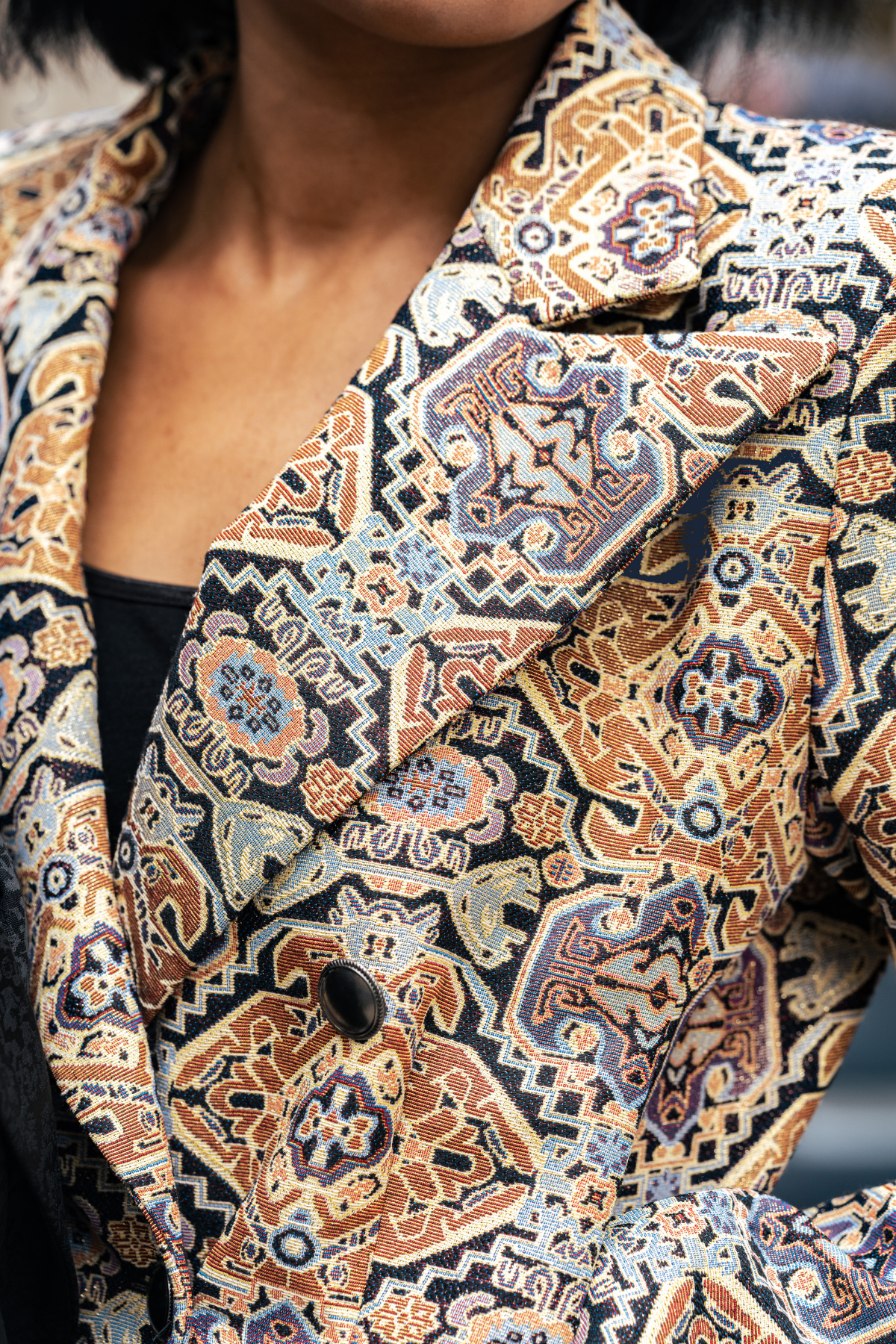 Close-up of a person wearing a patterned jacket with intricate designs.