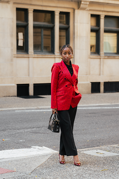 Woman in a red coat standing on a street corner